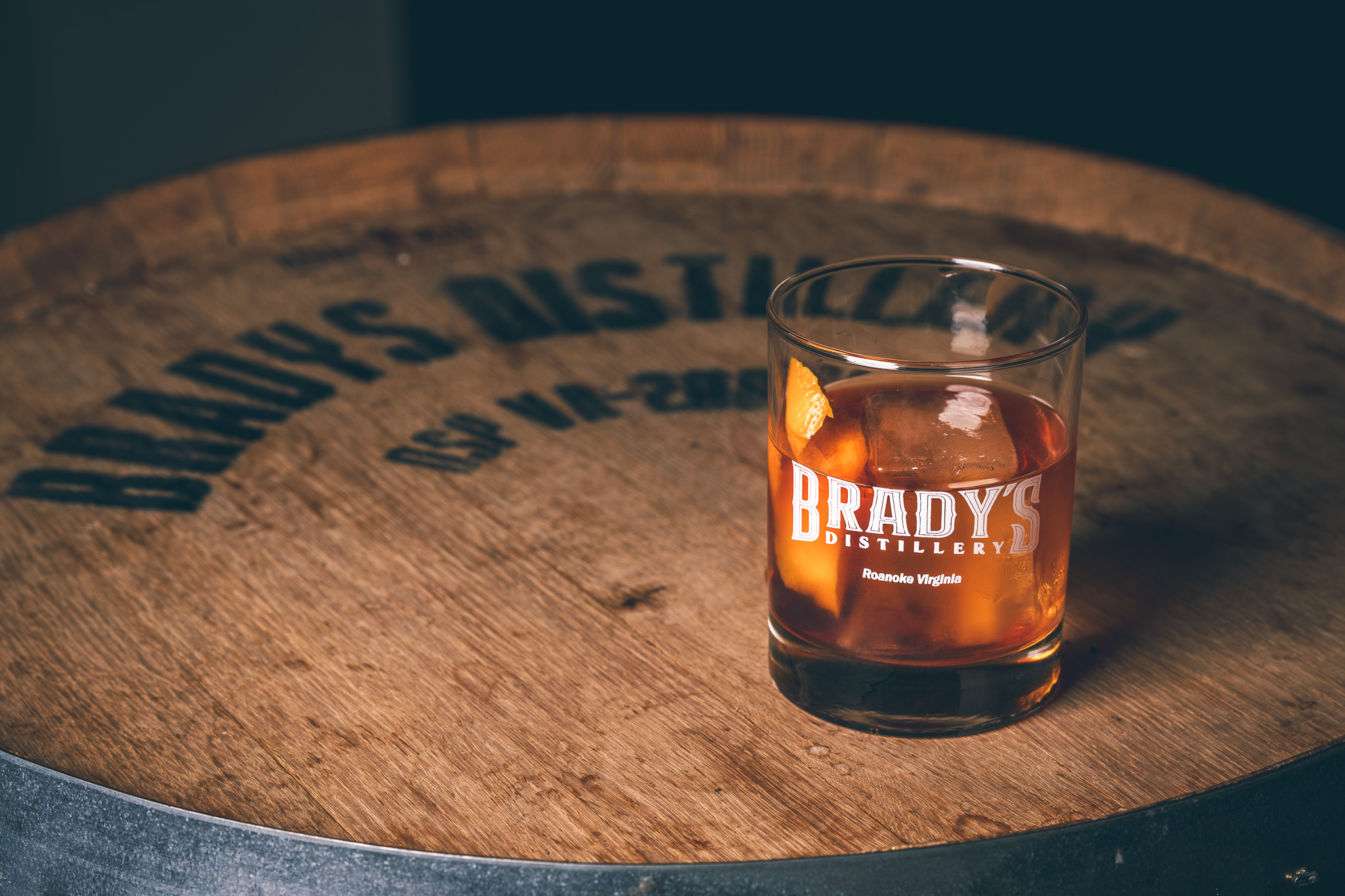 A Brady's cocktail resting on a whiskey barrel head